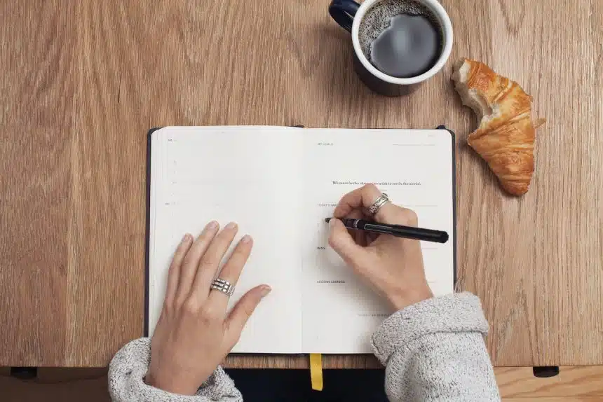 person writing on a book