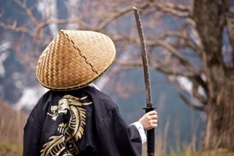 Garçon en costume de samouraï avec katana en arrière-plan