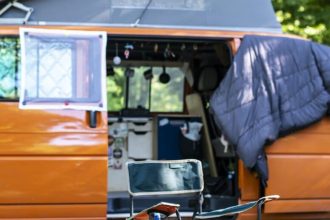 fourgon aménagé stationné dans un camping avec équipements extérieurs