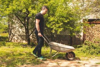 Homme transportant des matériaux avec un chariot dans un chantier de rénovation