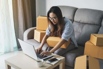 Jeune femme asiatique travaillant sur son commerce en ligne