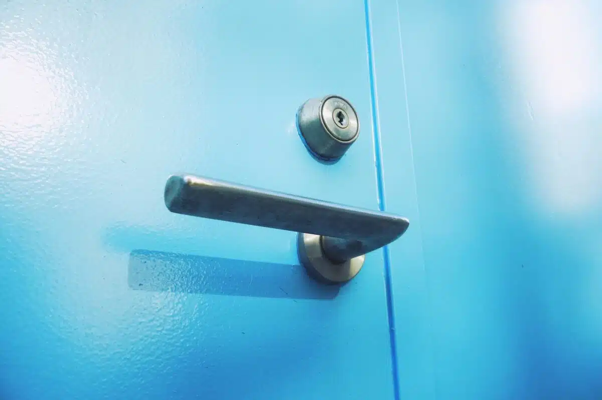 a close up of a door handle on a blue door